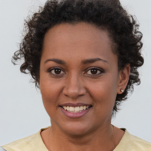 Joyful black young-adult female with short  brown hair and brown eyes