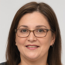 Joyful white adult female with long  brown hair and grey eyes