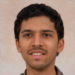 Joyful latino young-adult male with short  brown hair and brown eyes