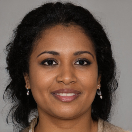 Joyful black young-adult female with long  brown hair and brown eyes