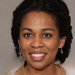 Joyful black adult female with long  brown hair and brown eyes