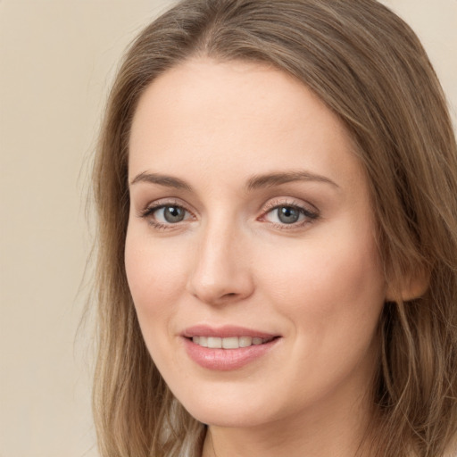 Joyful white young-adult female with long  brown hair and green eyes