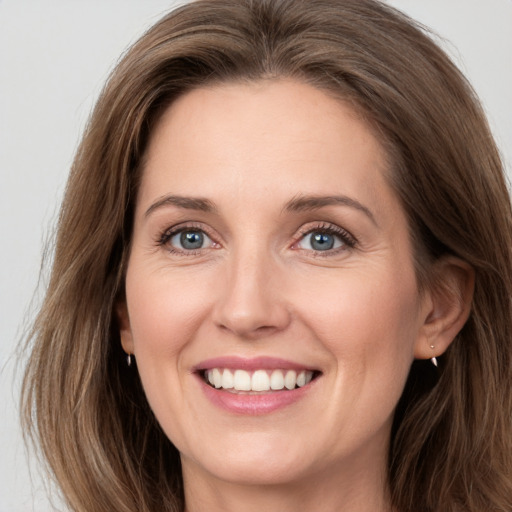 Joyful white young-adult female with long  brown hair and green eyes