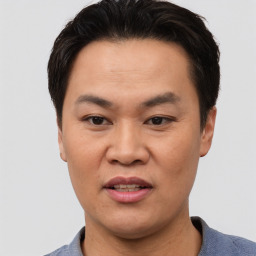 Joyful asian adult male with short  black hair and brown eyes