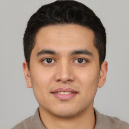 Joyful latino young-adult male with short  black hair and brown eyes