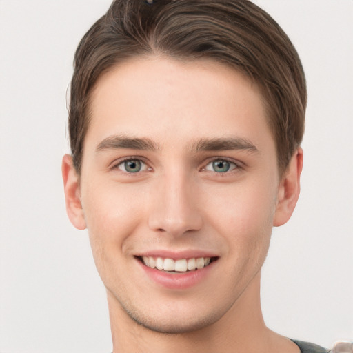 Joyful white young-adult male with short  brown hair and grey eyes