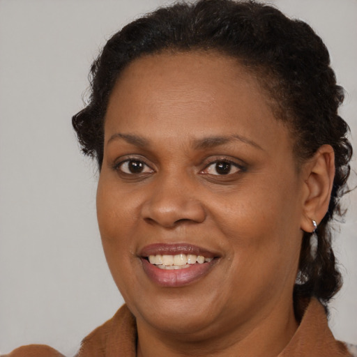 Joyful black adult female with medium  brown hair and brown eyes