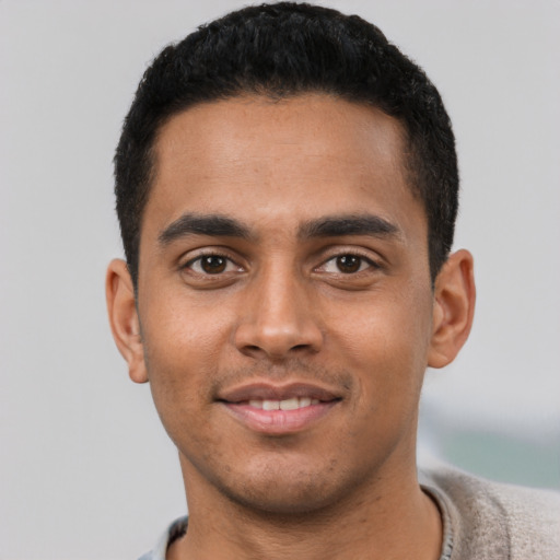 Joyful latino young-adult male with short  black hair and brown eyes