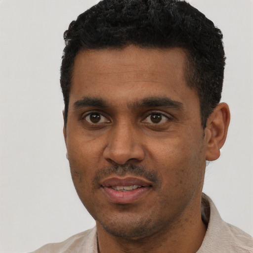 Joyful black young-adult male with short  black hair and brown eyes