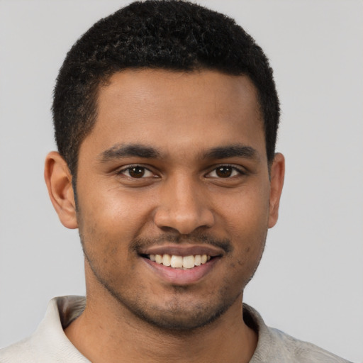 Joyful black young-adult male with short  brown hair and brown eyes