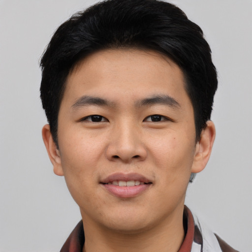 Joyful asian young-adult male with short  black hair and brown eyes