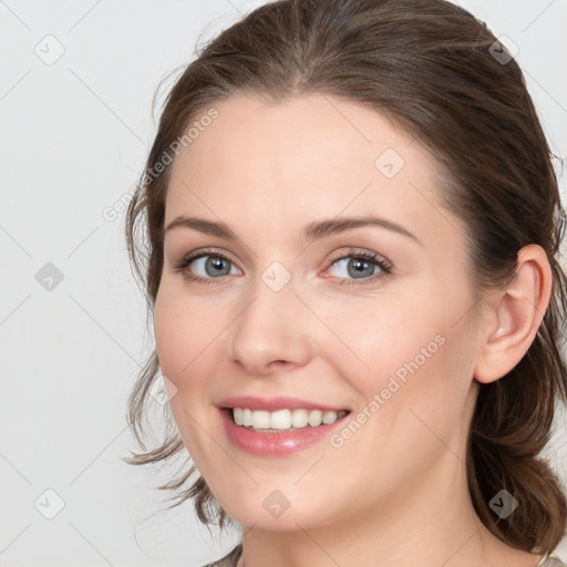 Joyful white young-adult female with medium  brown hair and blue eyes