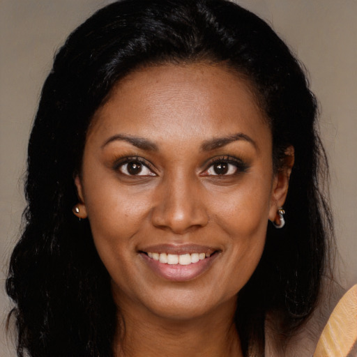 Joyful black young-adult female with long  brown hair and brown eyes