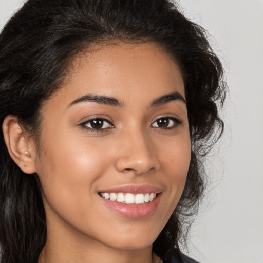 Joyful latino young-adult female with long  brown hair and brown eyes