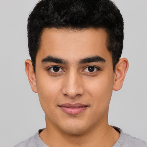 Joyful latino young-adult male with short  black hair and brown eyes