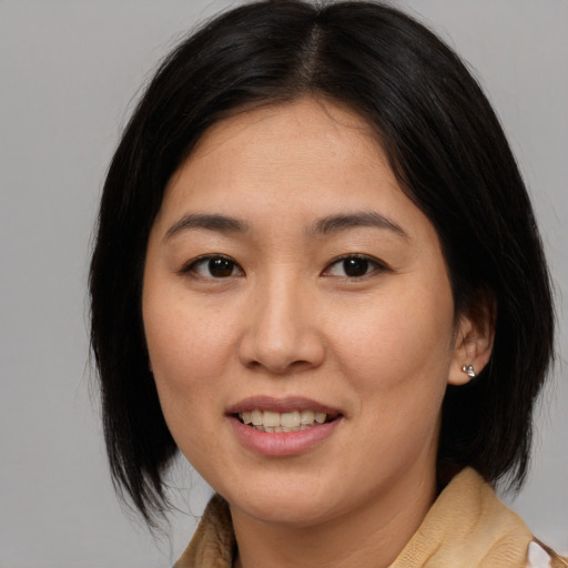 Joyful asian young-adult female with medium  brown hair and brown eyes