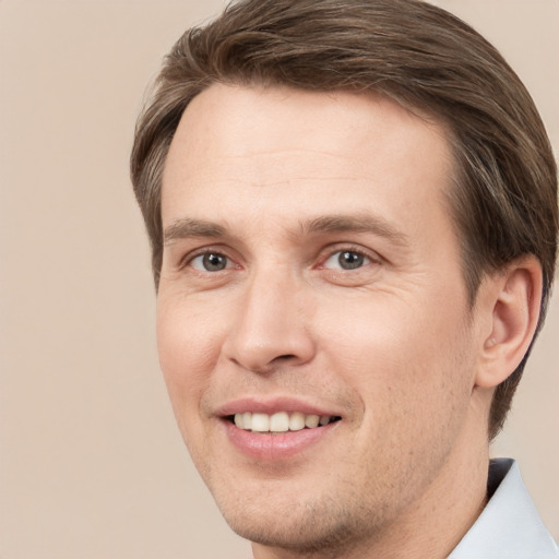 Joyful white young-adult male with short  brown hair and grey eyes