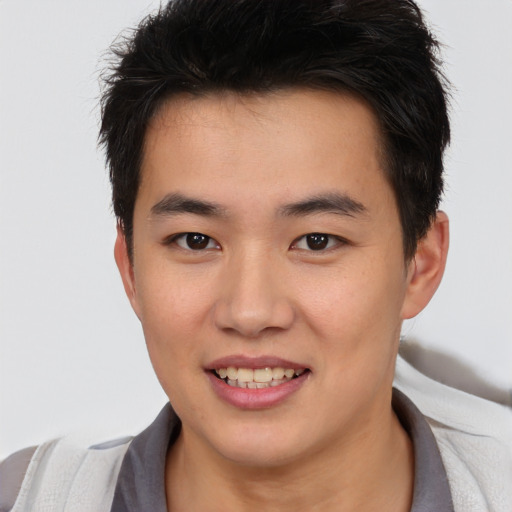 Joyful asian young-adult male with short  brown hair and brown eyes