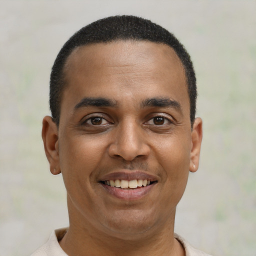 Joyful latino young-adult male with short  brown hair and brown eyes