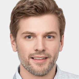 Joyful white young-adult male with short  brown hair and grey eyes