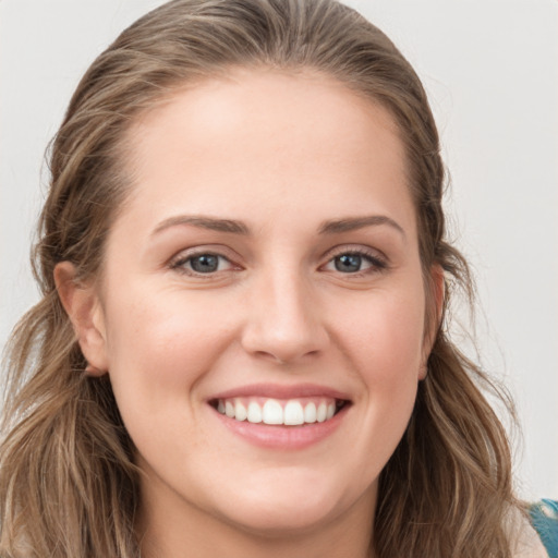 Joyful white young-adult female with long  brown hair and grey eyes