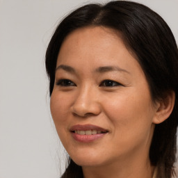 Joyful asian young-adult female with long  brown hair and brown eyes