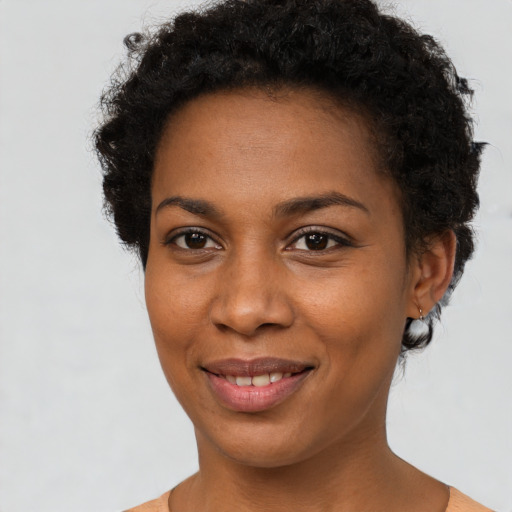 Joyful black young-adult female with short  brown hair and brown eyes