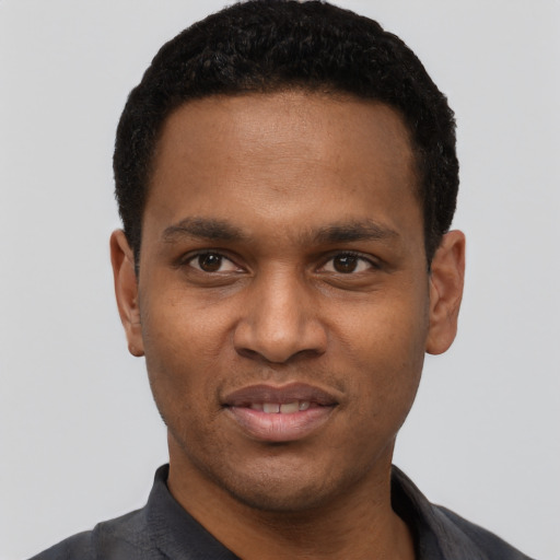 Joyful black young-adult male with short  black hair and brown eyes