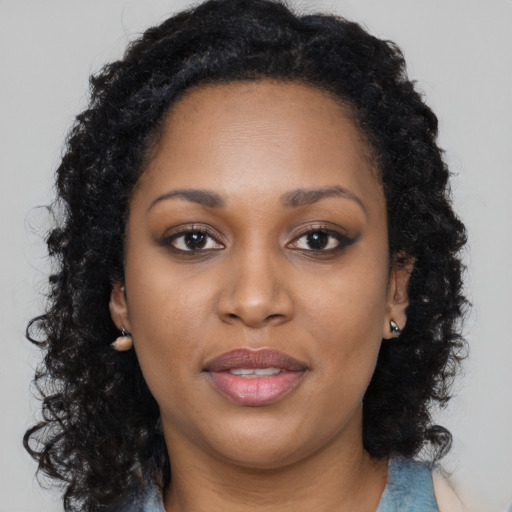 Joyful black young-adult female with long  brown hair and brown eyes