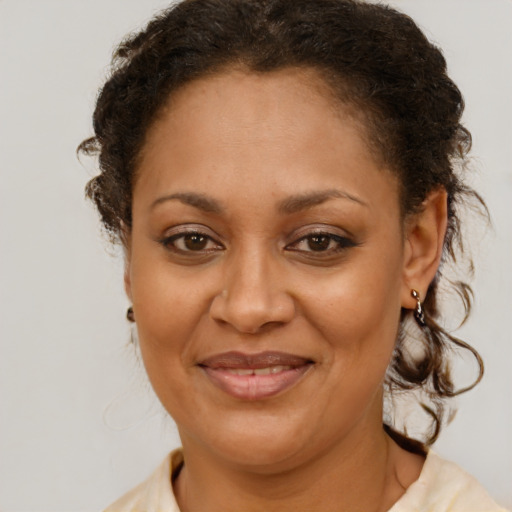 Joyful black adult female with medium  brown hair and brown eyes