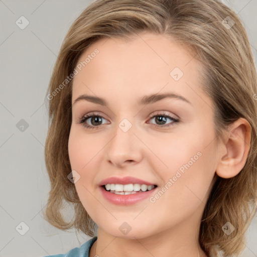 Joyful white young-adult female with long  brown hair and blue eyes