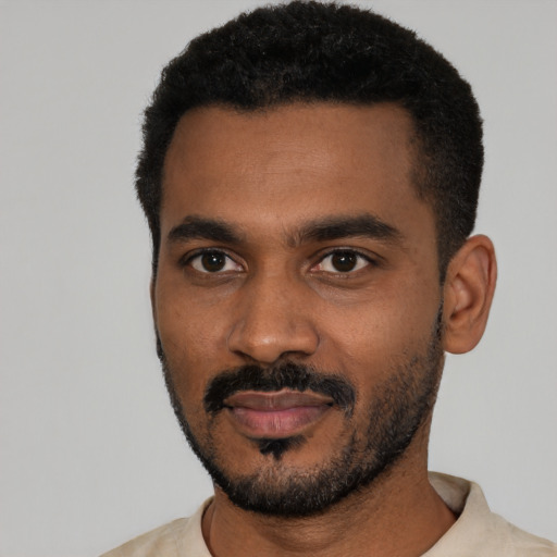 Joyful black young-adult male with short  black hair and brown eyes