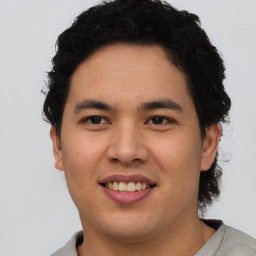 Joyful latino young-adult male with short  brown hair and brown eyes
