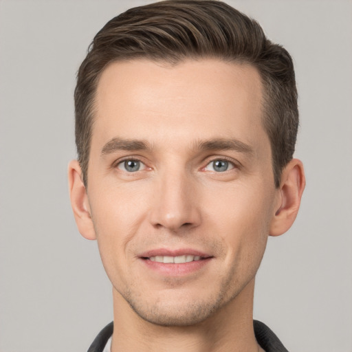 Joyful white young-adult male with short  brown hair and grey eyes