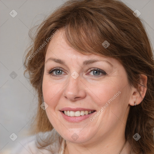 Joyful white adult female with medium  brown hair and blue eyes