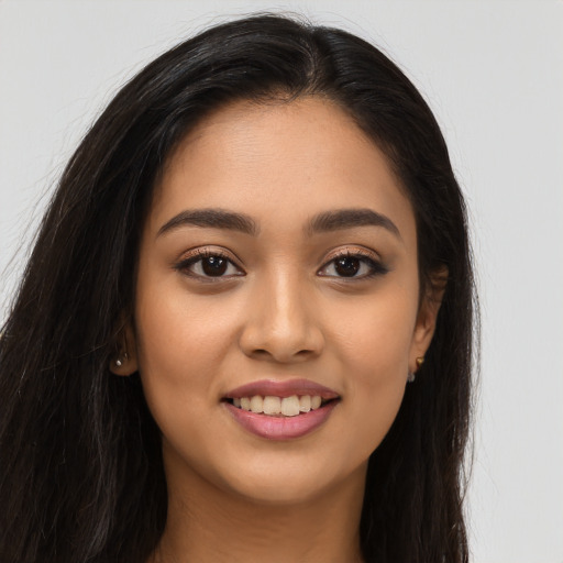 Joyful latino young-adult female with long  brown hair and brown eyes