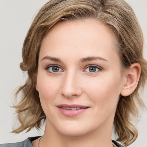 Joyful white young-adult female with medium  brown hair and blue eyes