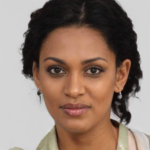 Joyful black young-adult female with medium  black hair and brown eyes