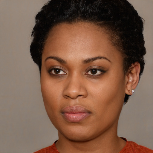 Joyful black young-adult female with short  brown hair and brown eyes