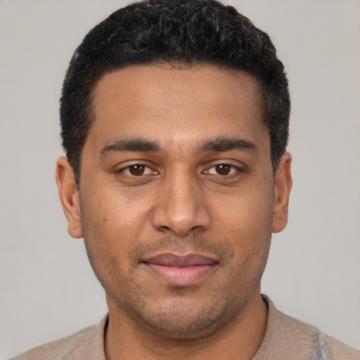 Joyful latino young-adult male with short  black hair and brown eyes