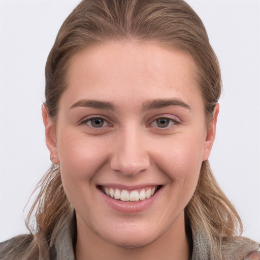 Joyful white young-adult female with long  brown hair and grey eyes