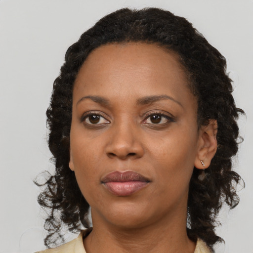 Joyful black adult female with medium  brown hair and brown eyes