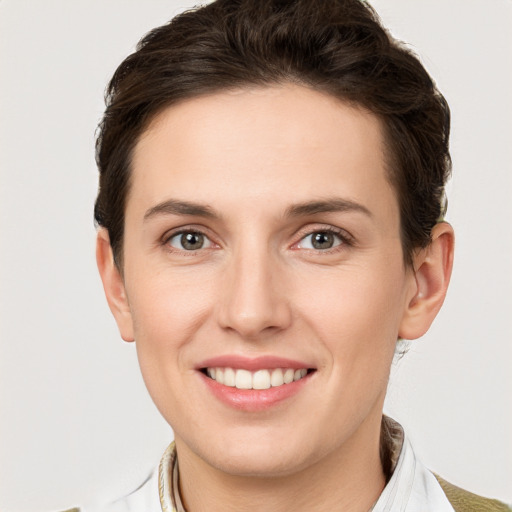 Joyful white young-adult female with short  brown hair and grey eyes