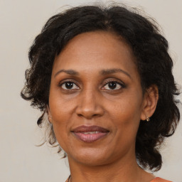 Joyful black adult female with medium  brown hair and brown eyes