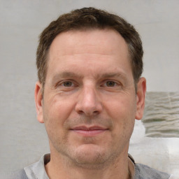 Joyful white adult male with short  brown hair and grey eyes