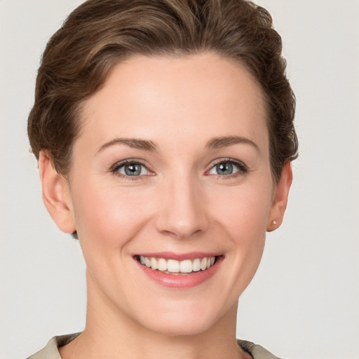 Joyful white young-adult female with short  brown hair and grey eyes