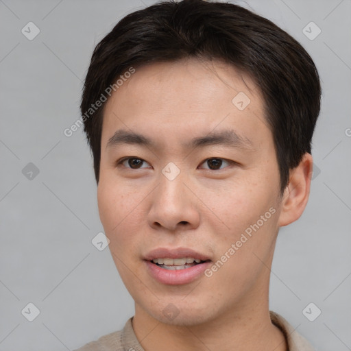 Joyful asian young-adult male with short  brown hair and brown eyes