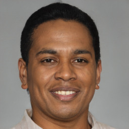 Joyful latino adult male with short  black hair and brown eyes