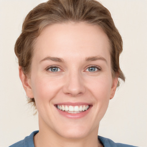 Joyful white young-adult female with short  brown hair and blue eyes