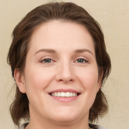 Joyful white young-adult female with medium  brown hair and green eyes